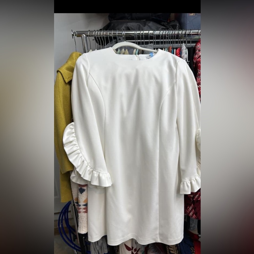 White dress to the knee. Fits well. Cute ruffle sleeve